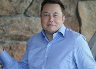 Elon Musk smiles at the camera.